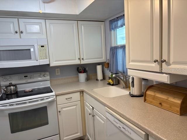 2218 Orange Blossom Ln Unit 0, Bradenton, FL 34207 - kitchen with white appliances, a sink, white cabinets, and light countertops