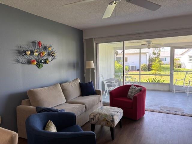 2218 Orange Blossom Ln Unit 0, Bradenton, FL 34207 - living room with a ceiling fan, a textured ceiling, and wood finished floors