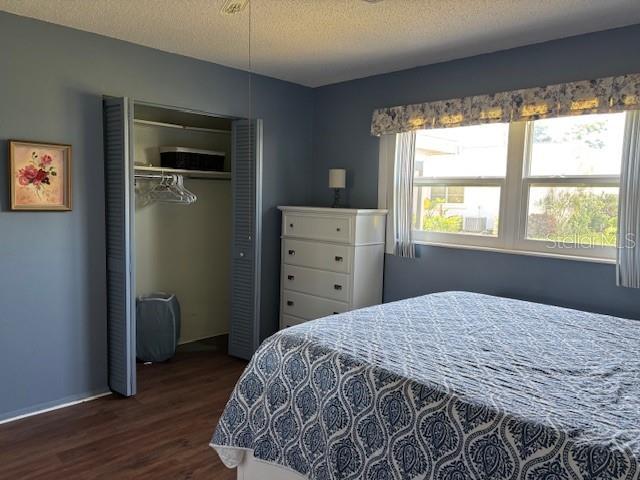 2218 Orange Blossom Ln Unit 0, Bradenton, FL 34207 - bedroom with dark wood-style floors, a closet, a textured ceiling, and baseboards