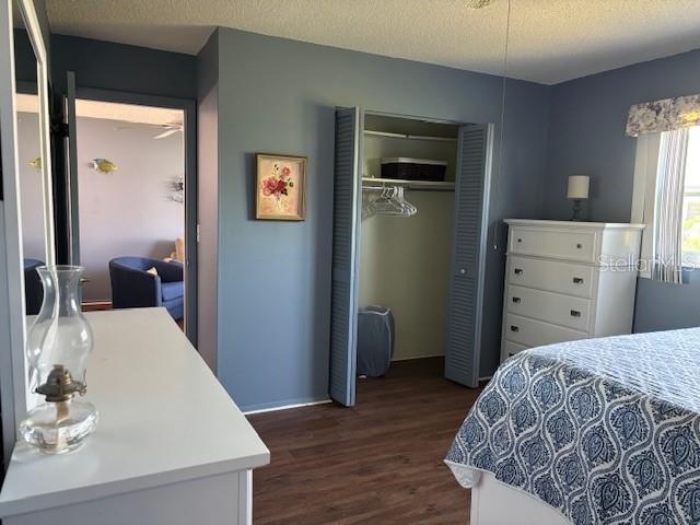 2218 Orange Blossom Ln Unit 0, Bradenton, FL 34207 - bedroom with dark wood-style flooring, a closet, baseboards, and a textured ceiling