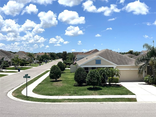view of front of home with driveway, an attached garage, a front lawn, and a residential view