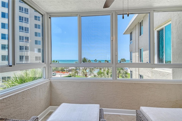 5916 Midnight Pass Rd Unit 404, Sarasota, FL 34242 - sunroom / solarium with baseboards, a water view, a textured ceiling, and a textured wall