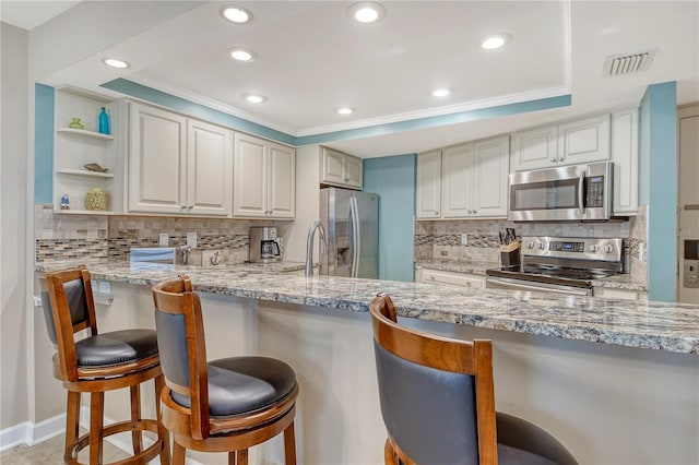 5916 Midnight Pass Rd Unit 404, Sarasota, FL 34242 - kitchen with appliances with stainless steel finishes, backsplash, recessed lighting, a kitchen bar, and light stone countertops