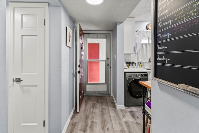 laundry room with washer / dryer, light wood-style flooring, and baseboards