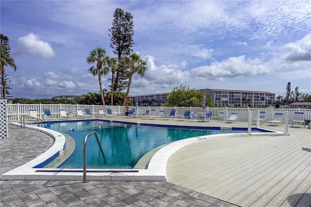 community pool with fence and a patio area