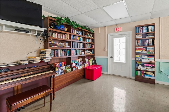 sitting room featuring a paneled ceiling and baseboards