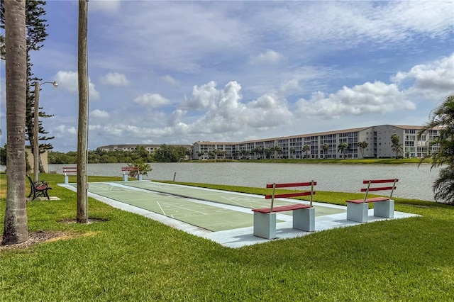 view of community with shuffleboard and a lawn