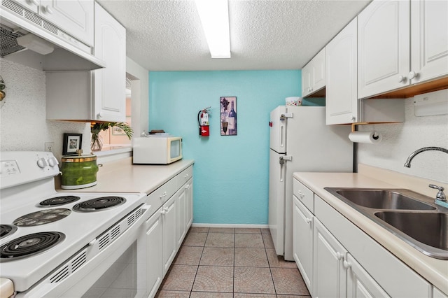kitchen with white appliances, under cabinet range hood, a sink, a textured ceiling, and white cabinetry