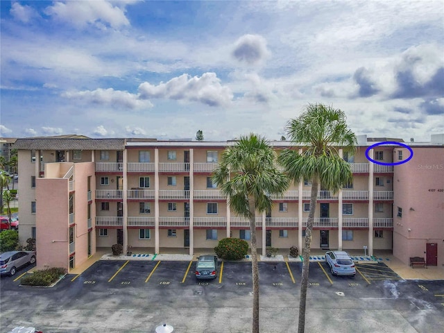 view of apartment building / complex featuring uncovered parking