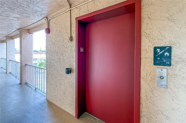 property entrance with elevator and stucco siding
