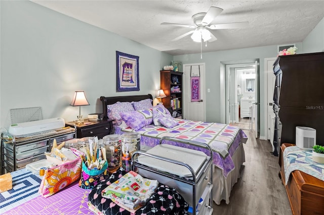 4189 Heron Way Unit 406E, Bradenton, FL 34205 - bedroom with wood finished floors, a ceiling fan, and ensuite bath