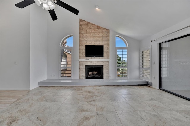 8710 54th Ave W Unit 8710, Bradenton, FL 34210 - unfurnished living room with a ceiling fan, a stone fireplace, baseboards, and high vaulted ceiling