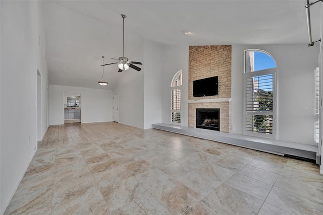 8710 54th Ave W Unit 8710, Bradenton, FL 34210 - unfurnished living room featuring ceiling fan, high vaulted ceiling, and a large fireplace