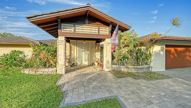 5500 Merrimac Dr, Sarasota, FL 34231 - view of exterior entry with a balcony, stucco siding, and an attached garage