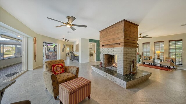 5500 Merrimac Dr, Sarasota, FL 34231 - tiled living room featuring a ceiling fan, plenty of natural light, a brick fireplace, and baseboards