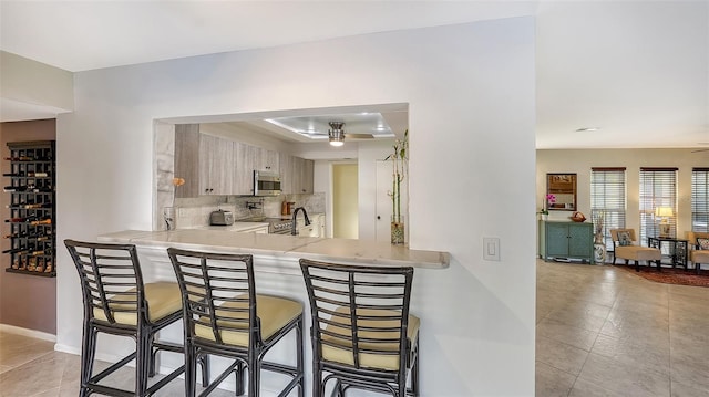 5500 Merrimac Dr, Sarasota, FL 34231 - kitchen with stainless steel microwave, decorative backsplash, light countertops, and a kitchen breakfast bar