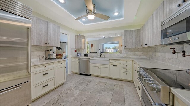 5500 Merrimac Dr, Sarasota, FL 34231 - kitchen featuring high quality appliances, a ceiling fan, decorative backsplash, light countertops, and a sink
