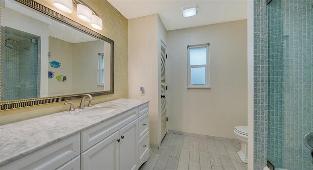 5500 Merrimac Dr, Sarasota, FL 34231 - bathroom featuring tiled shower, wood finished floors, toilet, vanity, and baseboards