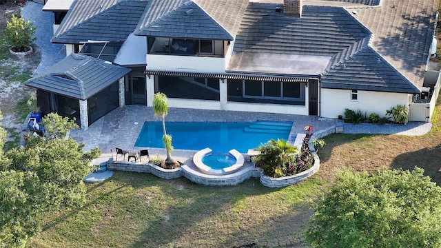 5500 Merrimac Dr, Sarasota, FL 34231 - rear view of house with a chimney, a patio area, a lawn, a pool with connected hot tub, and stucco siding