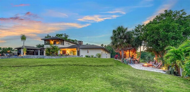 5500 Merrimac Dr, Sarasota, FL 34231 - view of front facade featuring a fire pit, a front yard, a chimney, a gazebo, and stucco siding