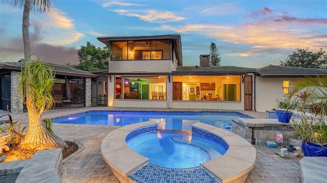 5500 Merrimac Dr, Sarasota, FL 34231 - rear view of property with an in-ground hot tub, an outdoor pool, a patio area, and a chimney
