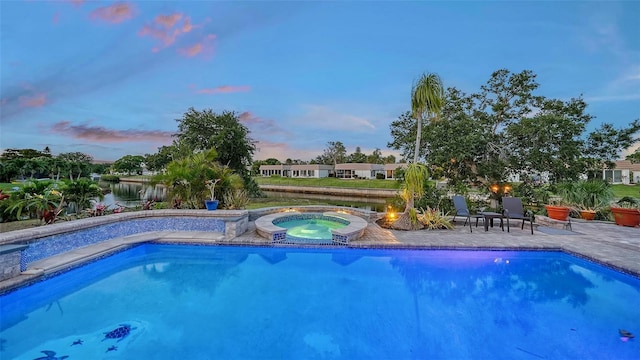 5500 Merrimac Dr, Sarasota, FL 34231 - pool at dusk featuring an in-ground hot tub, an outdoor pool, a patio, and a water view