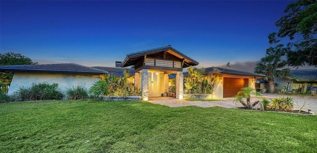 5500 Merrimac Dr, Sarasota, FL 34231 - view of front facade with driveway, a lawn, stucco siding, and an attached garage