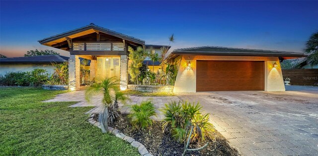 5500 Merrimac Dr, Sarasota, FL 34231 - view of front of property with decorative driveway, stucco siding, a front yard, and a garage