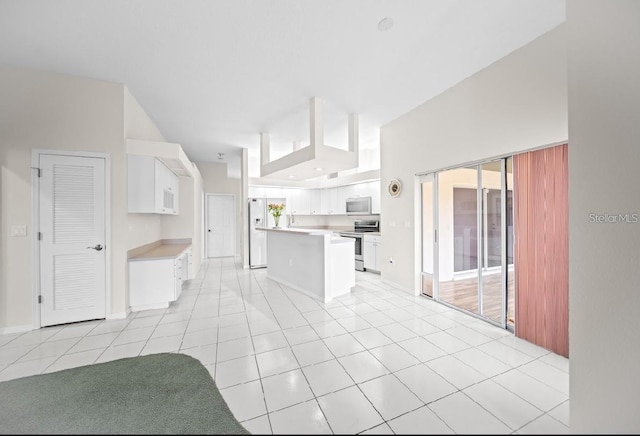 kitchen with white appliances, light countertops, white cabinetry, and light tile patterned floors
