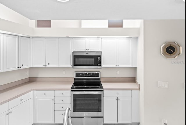 kitchen with appliances with stainless steel finishes, white cabinets, and light countertops