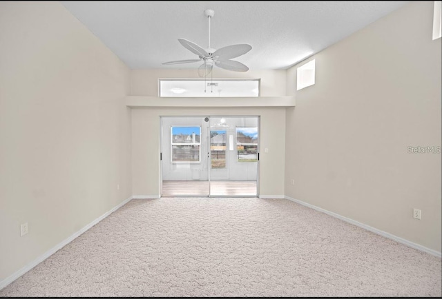 spare room with ceiling fan, carpet, and baseboards