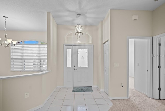 entryway featuring a chandelier, baseboards, and tile patterned floors