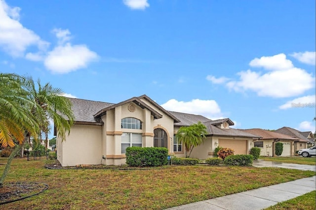 view of front facade featuring stucco siding, concrete driveway, an attached garage, and a front yard
