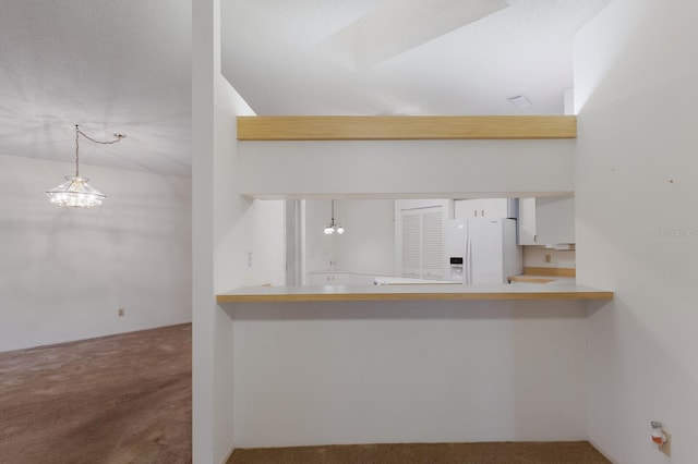 5712 Garden Lakes Dr, Bradenton, FL 34203 - kitchen with white refrigerator with ice dispenser, carpet flooring, hanging light fixtures, and a peninsula