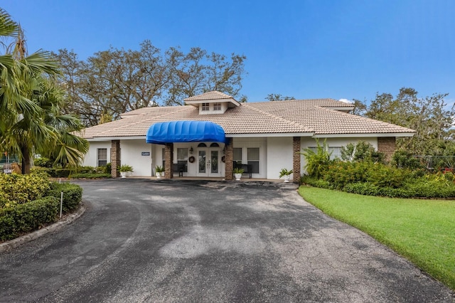 5712 Garden Lakes Dr, Bradenton, FL 34203 - mediterranean / spanish home with french doors, stucco siding, driveway, and a tile roof