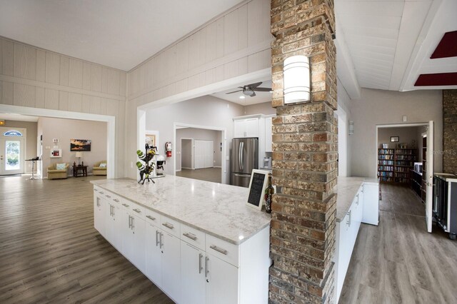 5712 Garden Lakes Dr, Bradenton, FL 34203 - kitchen with freestanding refrigerator, wood finished floors, ceiling fan, white cabinets, and light stone countertops