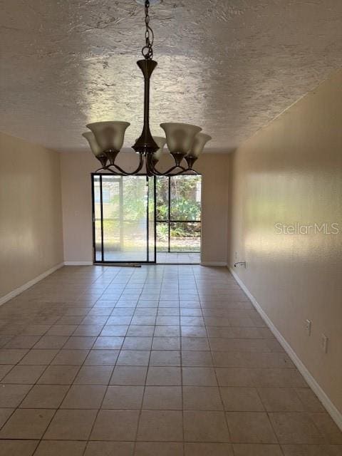 7273 Cloister Dr Unit 121, Sarasota, FL 34231 - tiled empty room with a textured ceiling, baseboards, and a chandelier
