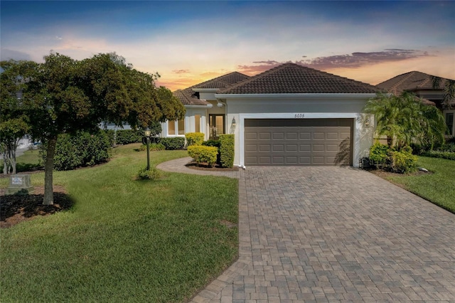 5035 Tobermory Way, Bradenton, FL 34211 - view of front facade featuring a garage, a front yard, decorative driveway, and stucco siding