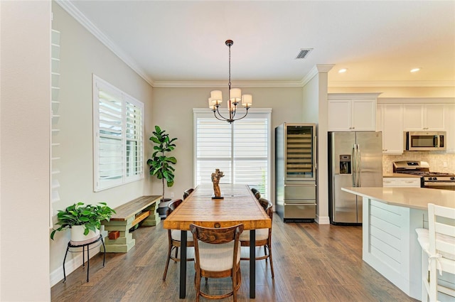 5035 Tobermory Way, Bradenton, FL 34211 - dining area with beverage cooler, a chandelier, ornamental molding, dark wood-type flooring, and baseboards