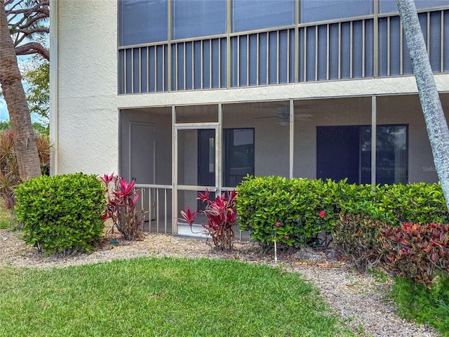 7500 40th Ave W Unit 108, Bradenton, FL 34209 - back of property with stucco siding, a sunroom, ceiling fan, and a lawn