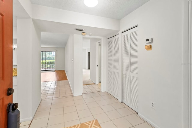 7500 40th Ave W Unit 108, Bradenton, FL 34209 - hall with light tile patterned floors, a textured ceiling, and baseboards