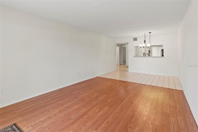 7500 40th Ave W Unit 108, Bradenton, FL 34209 - unfurnished living room with a chandelier and light wood-style flooring
