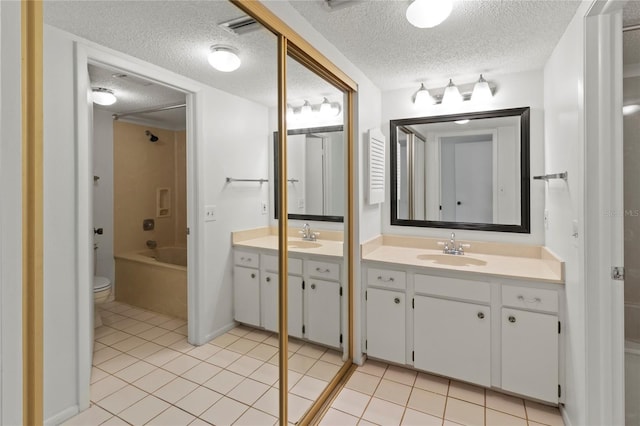 7500 40th Ave W Unit 108, Bradenton, FL 34209 - full bath featuring a textured ceiling, tile patterned floors, vanity, toilet, and tub / shower combination