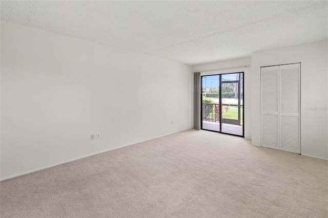 7500 40th Ave W Unit 108, Bradenton, FL 34209 - empty room with light carpet, a textured ceiling, and baseboards