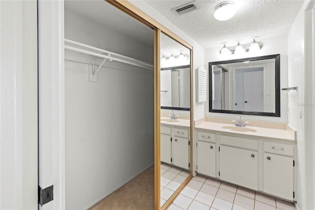 7500 40th Ave W Unit 108, Bradenton, FL 34209 - bathroom featuring vanity, a textured ceiling, tile patterned floors, and a walk in closet