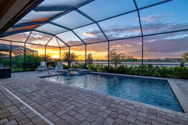 view of swimming pool with a patio area, a pool with connected hot tub, a water view, and glass enclosure