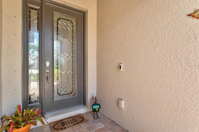 property entrance with stucco siding