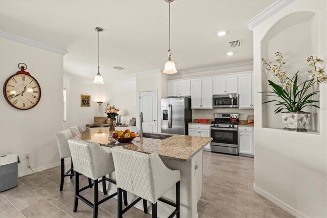 kitchen featuring stainless steel appliances, ornamental molding, a sink, a breakfast bar, and light stone counters