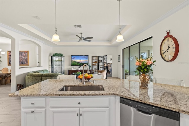 kitchen with dishwasher, a sink, a raised ceiling, open floor plan, and ornamental molding