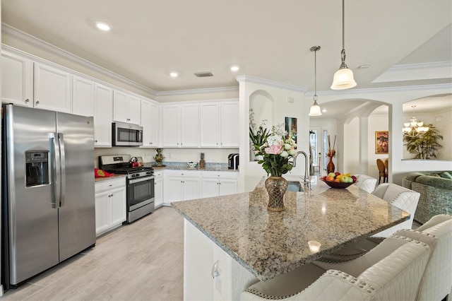 kitchen with stainless steel appliances, arched walkways, a kitchen bar, a sink, and crown molding
